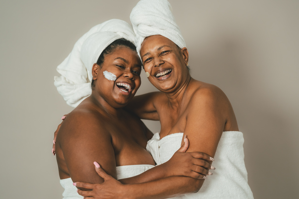Happy African multigenerational women having skin care spa day -